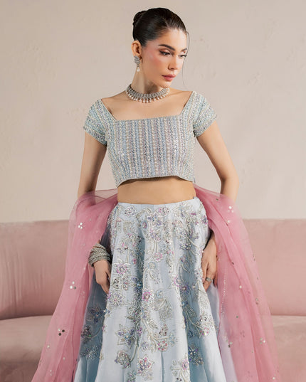 Eraya Serene Camellia ice blue embellished choli and lehnga with pink dupatta draped over the arm