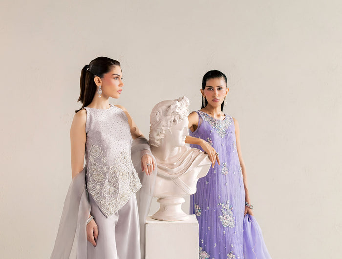 Eraya Seréne grey pearl-embellished peplum and lilac crushed silk gown beside a marble bust