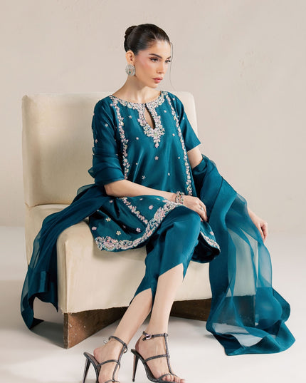 Eraya Serene Opaline teal peplum and tulip shalwar shown seated with organza dupatta