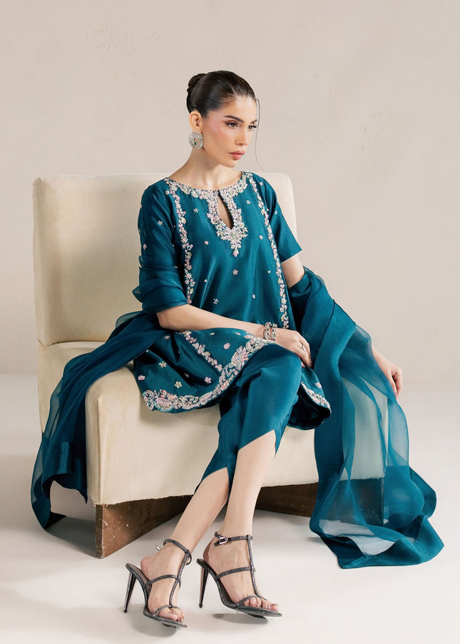 Eraya Serene Opaline teal peplum and tulip shalwar shown seated with organza dupatta