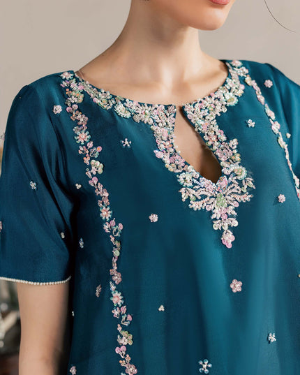 Close view of the Eraya Serene Opaline teal peplum neckline with pastel floral embellishment