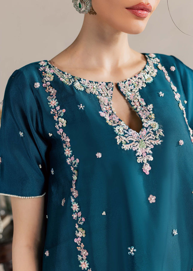 Close view of the Eraya Serene Opaline teal peplum neckline with pastel floral embellishment